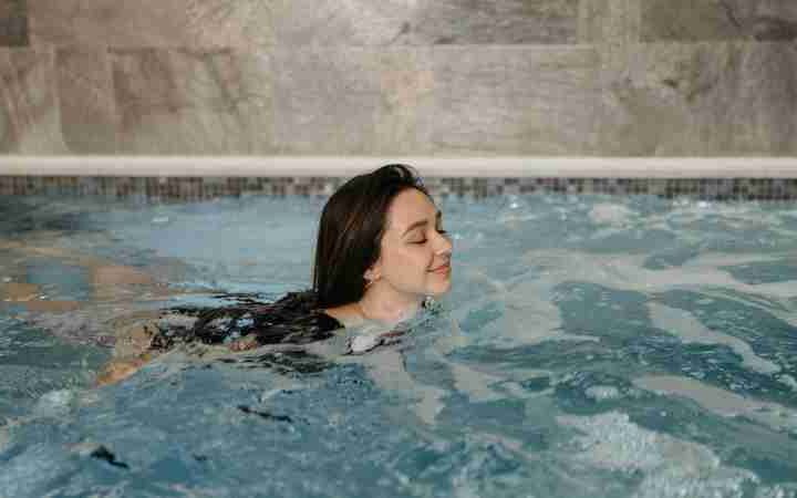 Woman swimming comfortably in an indoor pool, enjoying a peaceful moment., tags: entdeckt - pexel